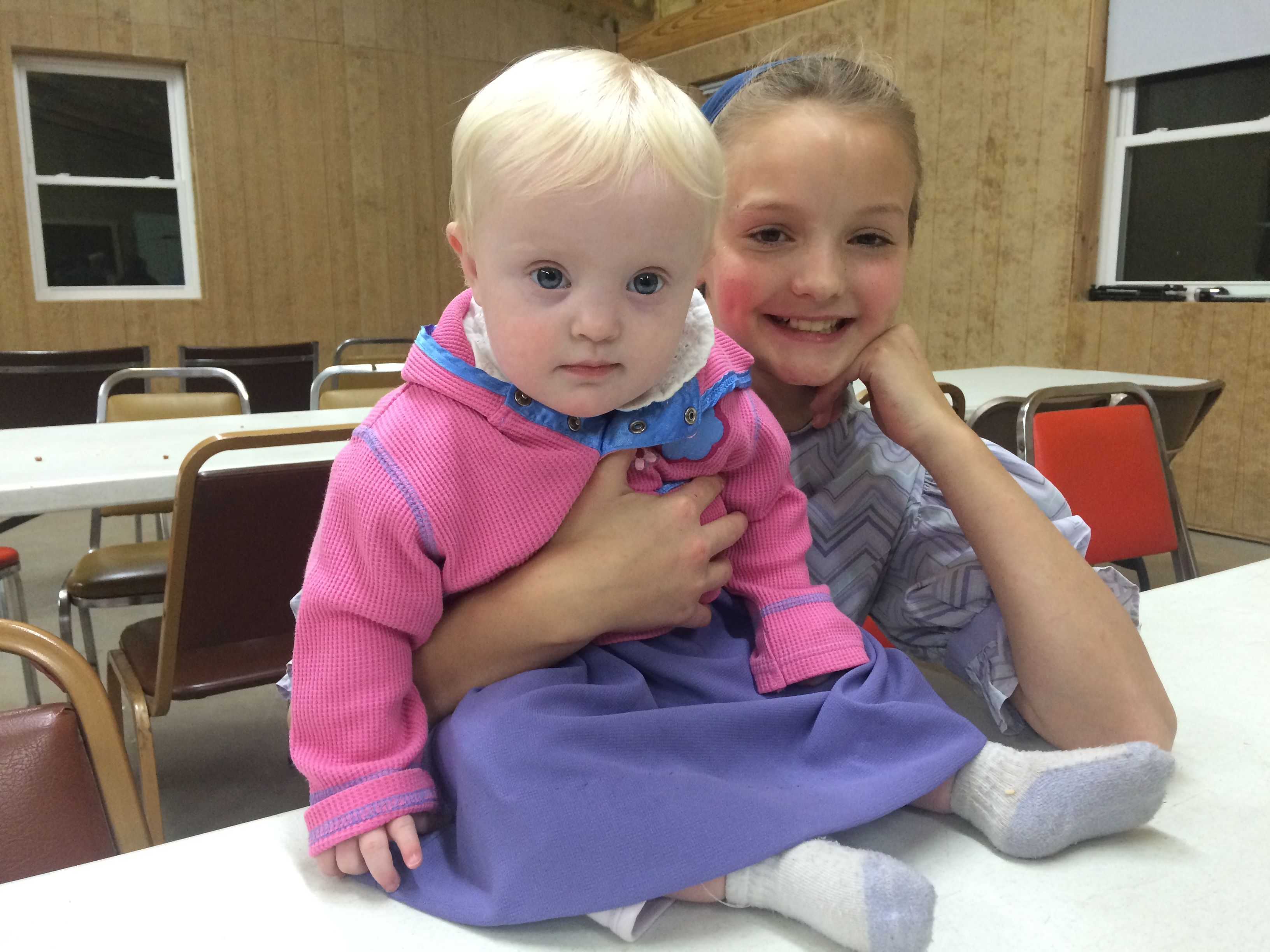 Girl and baby giving a smile